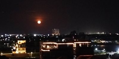 A photo of the moon rising over Phnom Penh looking bigger and more lustrous than usual. It is the Moon Illusion when the moon appears many times its usual size when close to the horizon. Taken 11 July 2025.